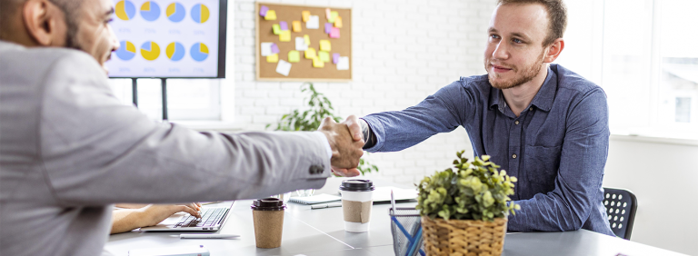 2 personnes se serrant la main après avoir fait une reconversion professionnelle